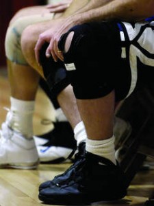 Knee Pain Spacialists athletes sitting on a bench wearing a knee brace