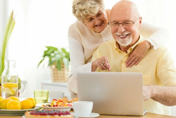 Lumbar Spinal Stenosis - happy couple looking at laptop