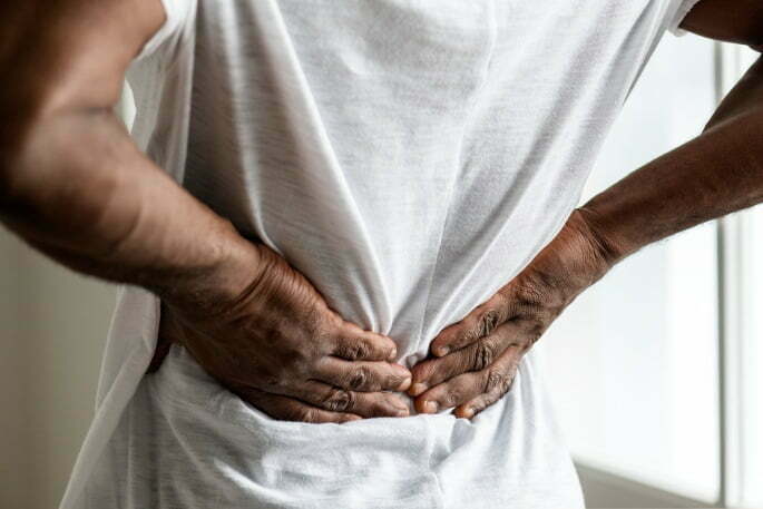 Herniated Disc - man holding lower back in pain