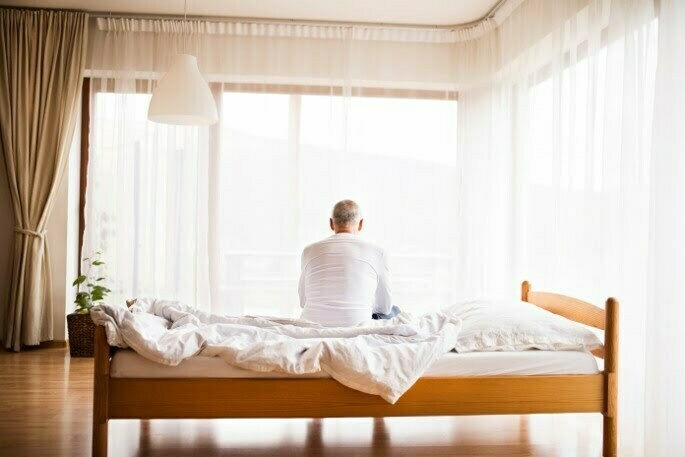 Lumbar Spinal Stenosis - man sitting on bed
