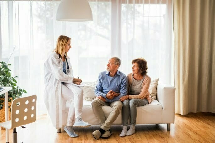 Pain Management - couple speaking to doctor on couch