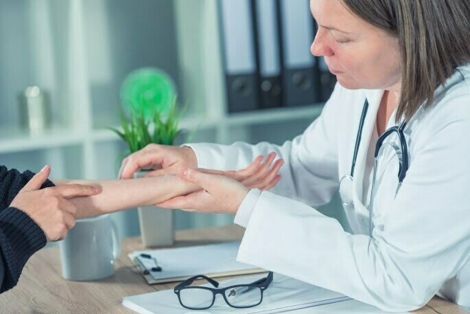 Pain Management Doctor Diagnosing Cervical Disc Herniation in Chicago Cervical Disc Herniation - doctor checking patients wrist and arm