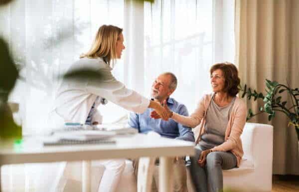 Ecstatic Couple Shaking Hands With Expert Pain Management Physicians