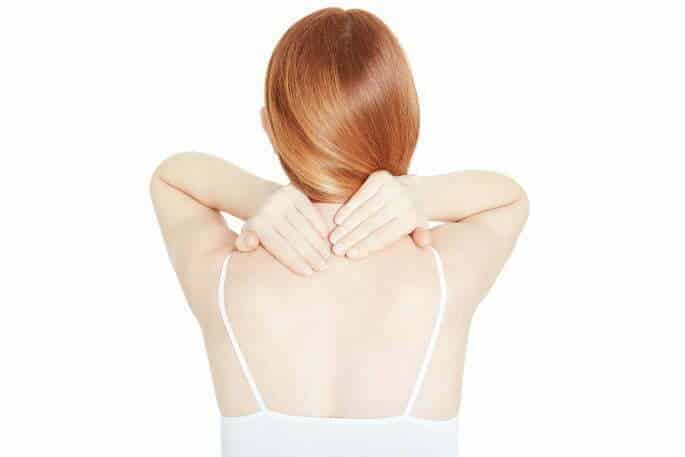 Woman With Upper Back And Neck Pain Holding Her Neck in Discomfort